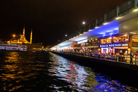 ISTANBUL, TURKEY - AUGUST 30, 2014: People on Galata Bridge at night. Galata Bridge is the most popular destinations for entertainment of Istanbul.のeditorial素材