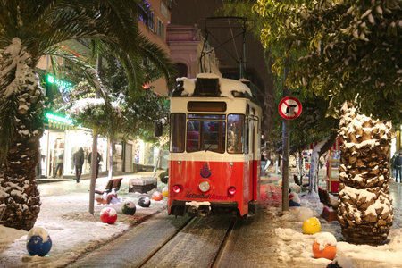 ISTANBUL, TURKEY - DECEMBER 31, 2015: Old red tram on snowy Bahariye Street. Bahariye Street is one of the most populer shopping area in Istanbul.のeditorial素材