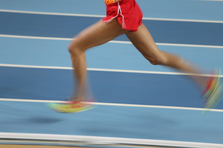 Blured athletes run in track and field