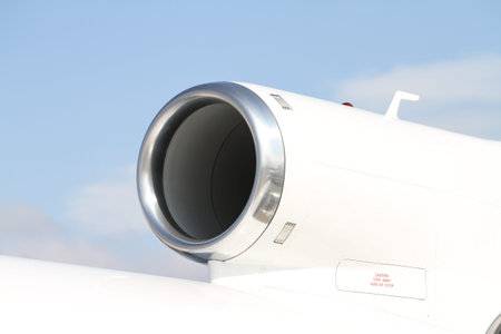 Engine of a white business jet on ground