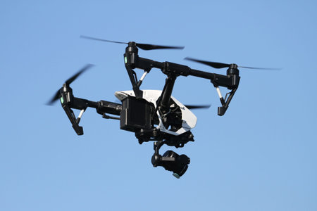 Black quadcopter helicopter is flying in sky