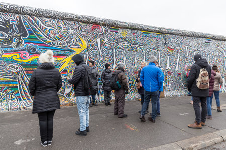 BERLIN, GERMANY - DECEMBER 16, 2017: People in front of Berlin Wall in East Side Gallery where the largest open air gallery in the worldのeditorial素材