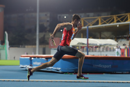 ISTANBUL, TURKEY - SEPTEMBER 13, 2020: Undefined athlete running 4x400 metres relay during Balkan U20 Athletics Championshipsのeditorial素材