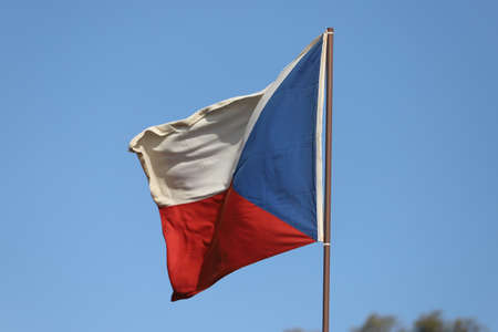 Czech Republic flag flying on flagpole on blue sky backgroundの写真素材