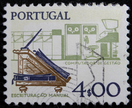 ISTANBUL, TURKEY - DECEMBER 26, 2020: Portugal stamp shows Old Desk and Computer, Designs: Work tools, old and new circa 1977のeditorial素材