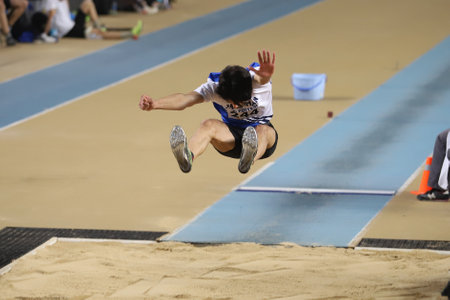 ISTANBUL, TURKEY - MARCH 14, 2021: Undefined athlete long jumping during Turkish Athletic Federation Municipalities Indoor Athletics Championshipsのeditorial素材