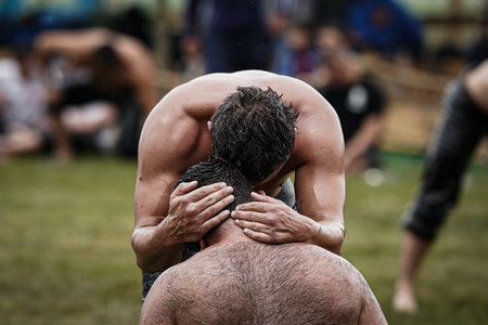 ISTANBUL, TURKIYE - JUNE 11, 2022: Oil wrestlers compete during Etnospor Culture Festival. Oil wrestling also called grease wrestling is the Turkish traditional sport.のeditorial素材