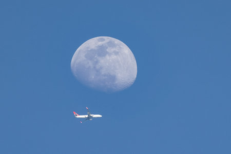 ISTANBUL, TURKIYE - MAY 01, 2023: Turkish Airlines plane and moon over Istanbul cityのeditorial素材