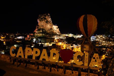 NEVSEHIR, TURKIYE - SEPTEMBER 26, 2024: Ortahisar Town in Cappadocia at night with Cappadocia signのeditorial素材