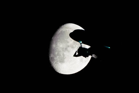 Silhouette of an Airplane in front of Moon at night