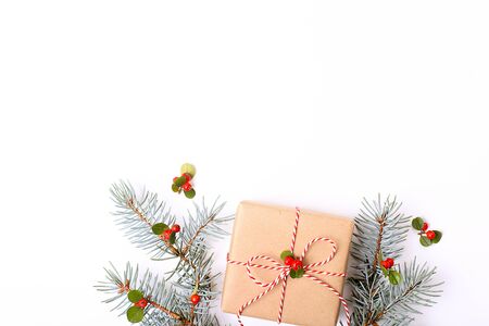 Christmas composition. Christmas gift, pine branch, and red berries. Top view, flat lay, copy space.の写真素材