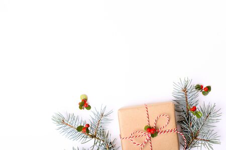 Christmas composition. Christmas gift, pine branch, and red berries. Top view, flat lay, copy space.の写真素材
