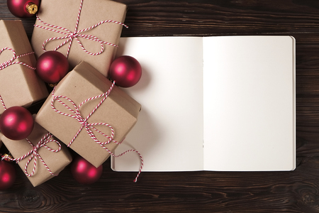 Notebook with christmas decoration and gifts on a wooden background. To do list, santa letter concept. Top view, flat lay, text spaceの写真素材