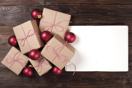 Notebook with christmas decoration and gifts on a wooden background. To do list, santa letter concept. Top view, flat lay, text space.の写真素材
