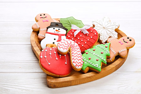 Various types of Christmas decorative gingerbread cookies on a wooden table top view, text space