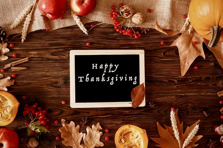 Happy thanksgiving concept. Still life composition with pumpkin and oher fruits and vegetble small decoration with funny font text white text. Wood textured table background. Top view, close up.の写真素材