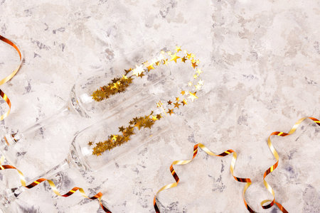 Festive composition with champagne & golden glitter. Traditional New Year celebration. Winter...