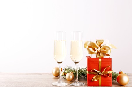 Beautiful christmas composition with two glasses of sparkling wine, decorations on wood textured table. New year's eve tradition to celebrate with champagne. Close up, copy space, background.の写真素材