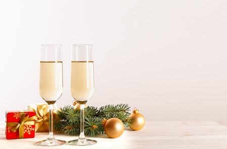 Beautiful christmas composition with two glasses of sparkling wine, decorations on wood textured table. New year's eve tradition to celebrate with champagne. Close up, copy space, background.の写真素材