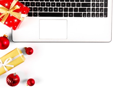 Online shopping for winter holidays concept. Flat lay composition with white laptop, black keyboard and traditional festive Christmas decoration. Close up, copy space, background, top view.の写真素材