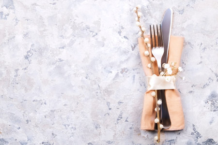 Easter table setting composition: fork, knife silverware wildflowers, pussy willow on plate w/...