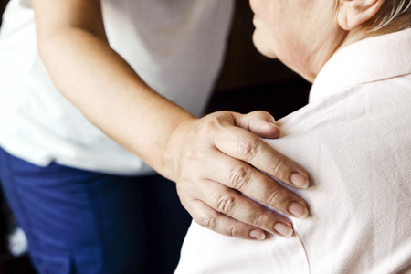 Mature female in elderly care facility gets help from hospital personnel nurse. Senior woman, aged wrinkled skin & hands of her care giver. Grand mother everyday life. Background, copy space, close upの写真素材
