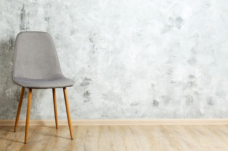Empy loft style chair over blank wall background wit a lot of copy space for text. Available job position, interview or negotiations concept.の写真素材