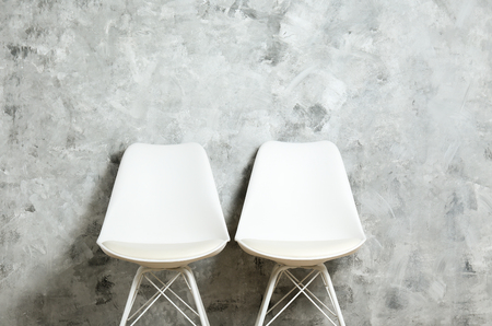 Empy loft style chair over blank wall background wit a lot of copy space for text. Available job position, interview or negotiations concept.の写真素材