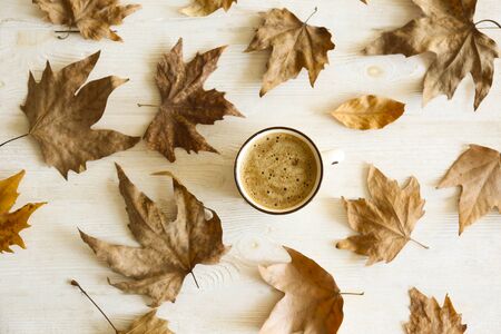 Top view composition with vintage styled cup of coffee and autumn themed decoration, fallen leaves on textured background. Top view, flat lay, copy space.の写真素材