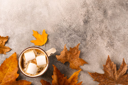 Top view composition with vintage styled cup of coffee with marshmallows and autumn themed...
