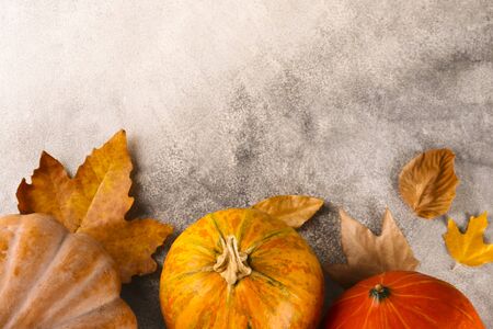 Thanksgiving background concept. Local produce pumpkin and autumn leaves with other decoration on textured table. Close up, copy space for text, top view, flat lay.の写真素材