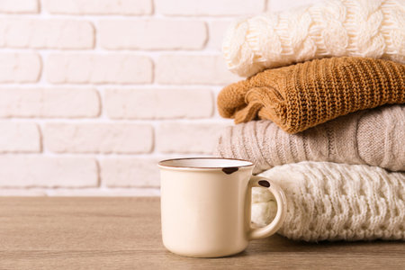 Bunch of knitted pastel color sweaters with different knitting patterns perfectly folded in stack on...