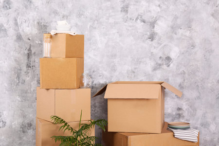 Bunch of blank unsigned moving boxes in new empty apartment. Spacious unfurnished room with unpacked...