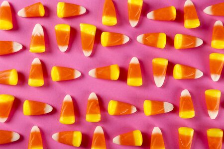 Bunch of candy corn sweets as sybol of Halloween hoiday on textured background with a lot of copy space for text. Flat lay composition for all hallows eve. Top view shot.の写真素材