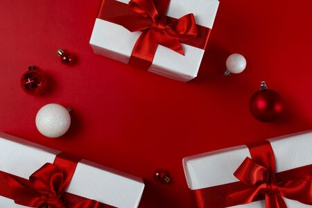 Bunch of christmas presents wrapped in red and white paper tied with shiny silk bow. Multiple new years gifts in red and white wrapping. Top view, close up, copy space, background, flat lay.の写真素材