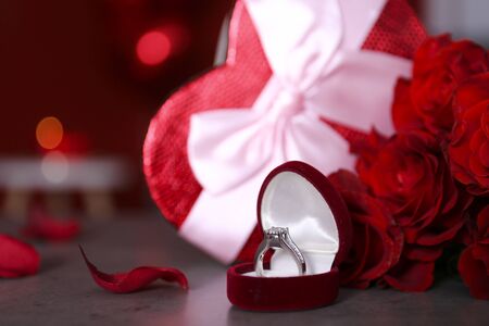 Marry me concept, wedding / engagement ring with red candles, roses bouquet, heart shaped air balloon. Happy st. valentine's day concept. Close up, copy space, front viewの写真素材