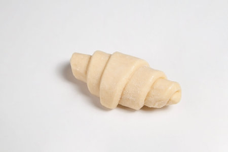 Close up studio shot of semi-finished frozen ready to cook croissant isolated on white background. Uncooked traditional french pastry. Copy space, top view.の写真素材