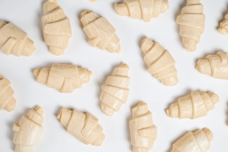 Close up studio shot of semi-finished frozen ready to cook croissant isolated on white background....