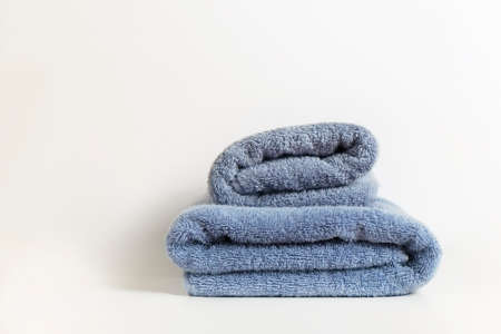 Studio shot of two grey folded towels of different size isolated on white background with a lot of copy space for text. Top view, close up.の写真素材