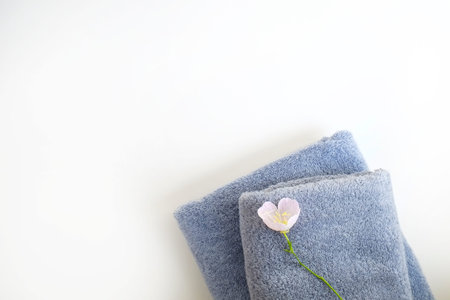 Studio shot of two grey folded towels of different size isolated on white background with a lot of...