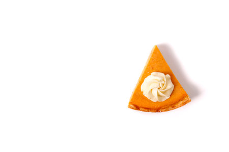 Piece of pumpkin pie with whipped cream isolated on white background.の写真素材