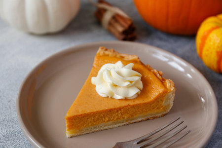 Pumpkin pie with whipped cream on a plate, close-upの写真素材