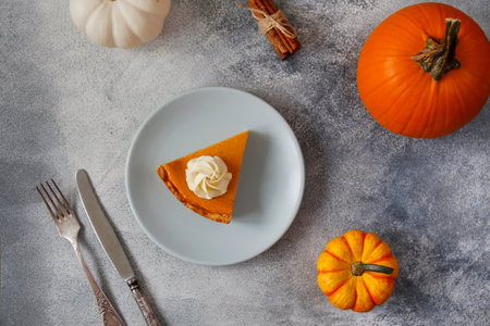 Pumpkin pie with whipped cream on a blue plate, top viewの写真素材