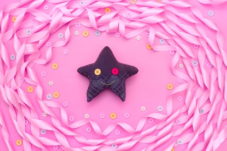 Textile toy heart and star on a festive background of satin ribbon.の写真素材