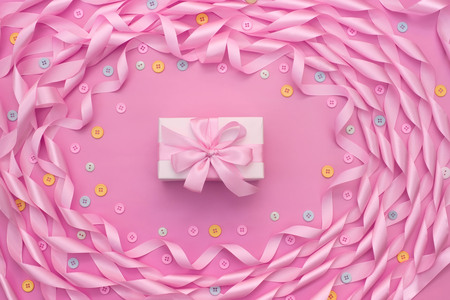 Decorative frame of satin ribbon pink. Gift box decorated with a bow. Background pinkの写真素材