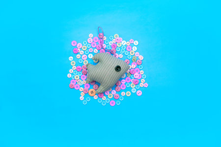 Textile toy fish on the background of the buttons. Common gentle blue background. Top view Flat Lay