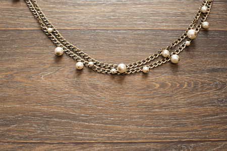 Decorative composition of women's jewelry on wooden dark background. Flat lay. The view from the top. The concept of fashion and beautyの写真素材