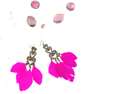A set of jewelry for women. Necklace with large beads, earrings with feathers pink. White backgroundの写真素材
