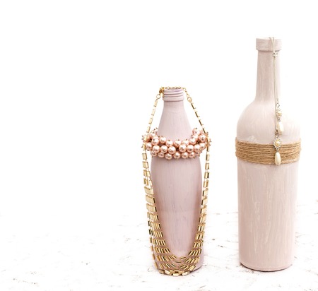 Bottle for home decoration on textured background. Paint, decor twine. Women's jewellery, necklace, bracelet.の写真素材