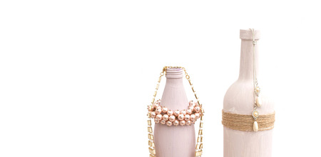 Bottle for home decoration on textured background. Paint, decor twine. Women's jewellery, necklace, bracelet.の写真素材
